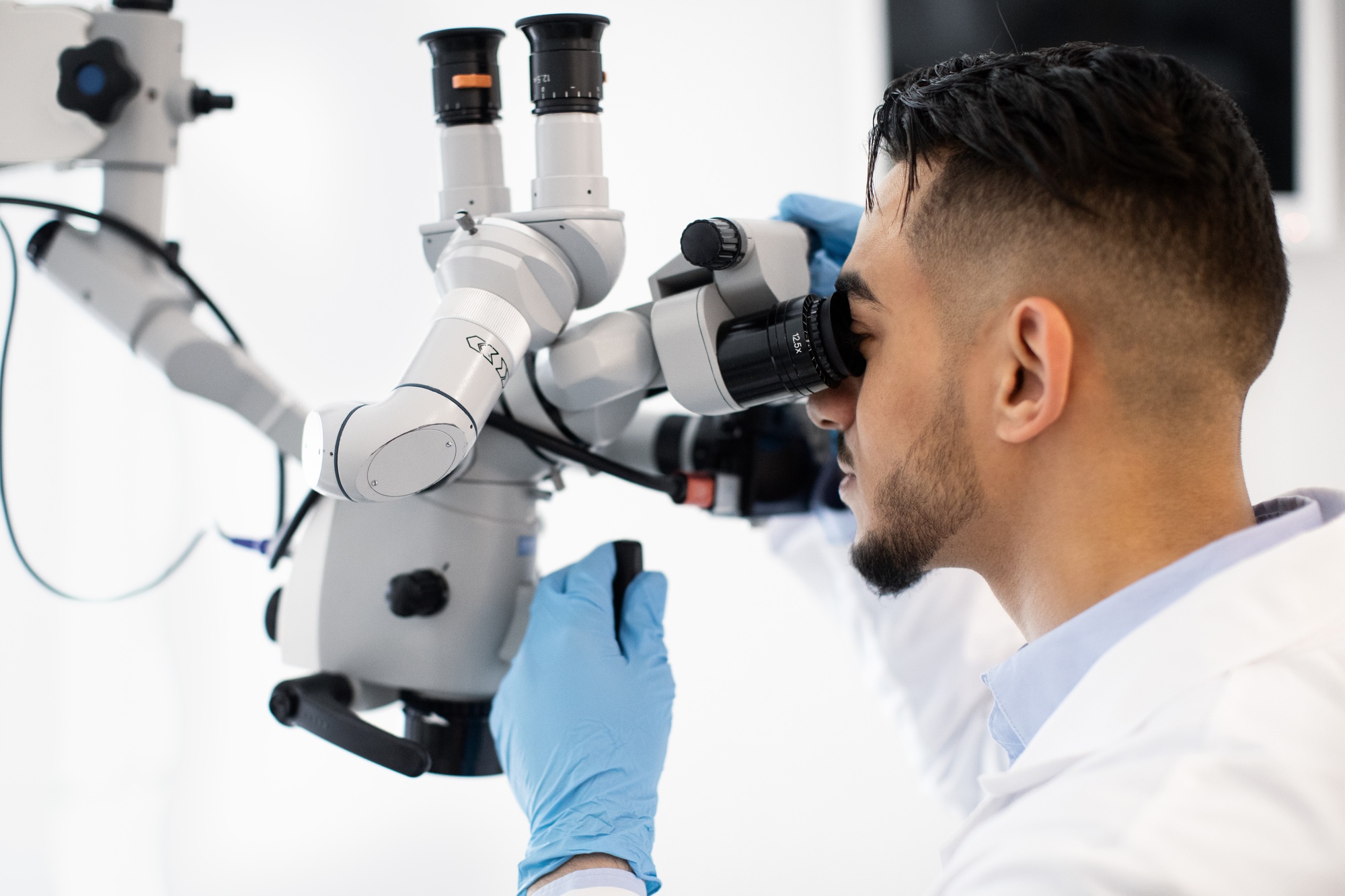 Modern Technologies For Healthcare. Arab Doctor Using Dental Microscope In Clinic